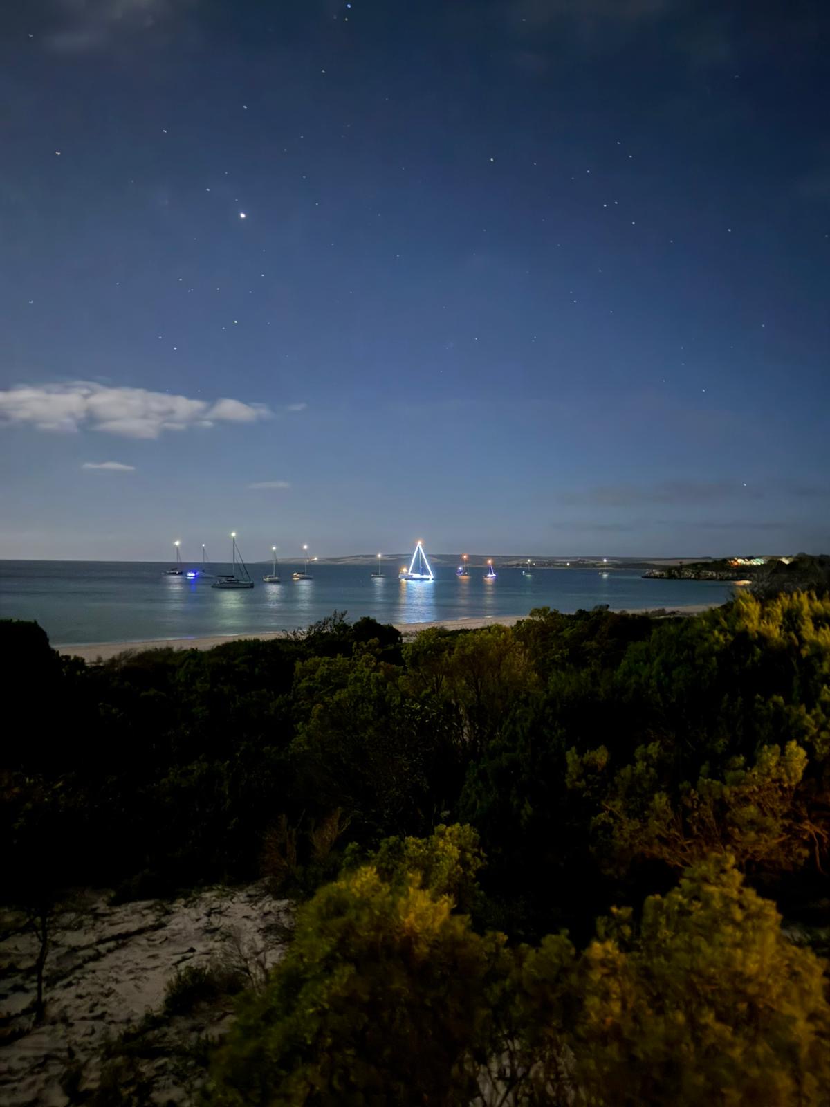 Nighttime harbor with boats and stars